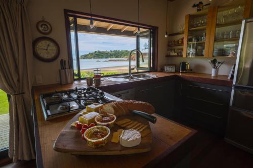 a kitchen with a cutting board with fruit on it at Absolute Beach front-Tutukaka Harbour in Tutukaka