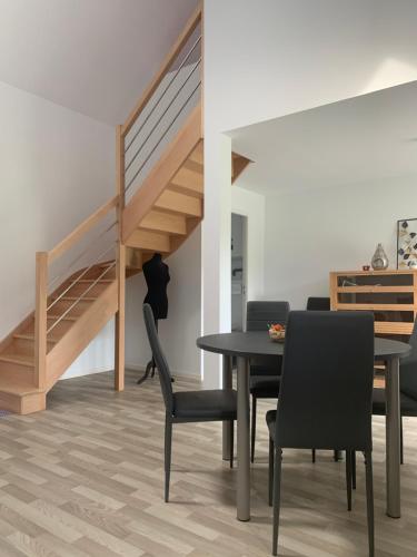 une salle à manger avec une table et des chaises et un escalier dans l'établissement Parc ar Brun Bihan, à Minihy-Tréguier