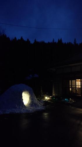 a pile of snow at night with a building at Lien Tono in Tōno