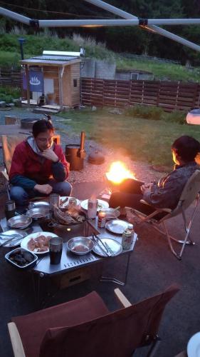 a group of people sitting around a table with a fire at Lien Tono in Tōno