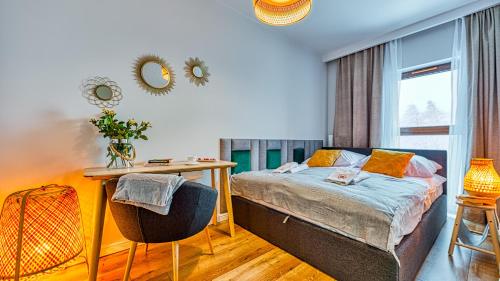 a bedroom with a bed and a desk and a window at Apartament D19 z Basenem, Sauną, Jacuzzi Green Park Resort - 5D Apartments in Szklarska Poręba