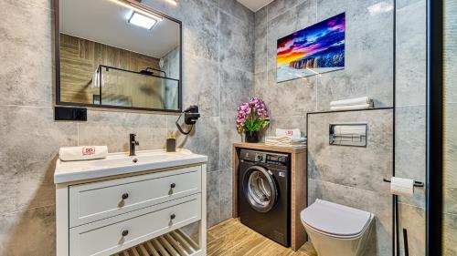 a bathroom with a washing machine and a sink at Apartament D19 z Basenem, Sauną, Jacuzzi Green Park Resort - 5D Apartments in Szklarska Poręba