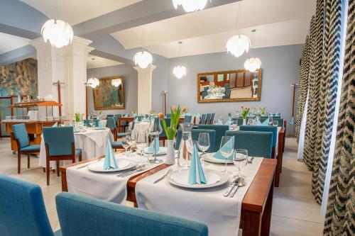 een eetkamer met tafels en stoelen en kroonluchters bij Hotel Academic in Zvolen
