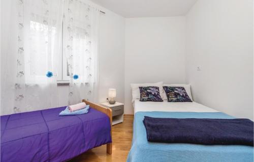 a bedroom with two beds with purple sheets and a window at Stunning Apartment In Kastav With House Sea View in Kastav