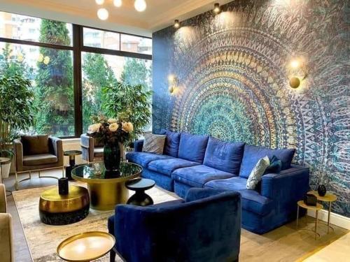 salon z niebieską kanapą i malowidłem ściennym w obiekcie Hotel Rogge w mieście Reşiţa