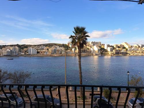 a view of a body of water with cars parked at Seafront Apartment in St. Paul's Bay in St Paul's Bay