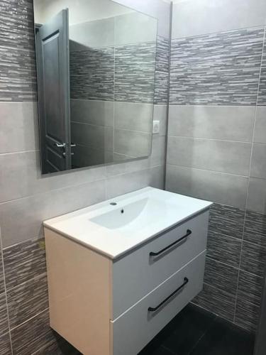 a bathroom with a white sink and a mirror at L'Imprévu est une maison individuelle. in Sennecey-le-Grand