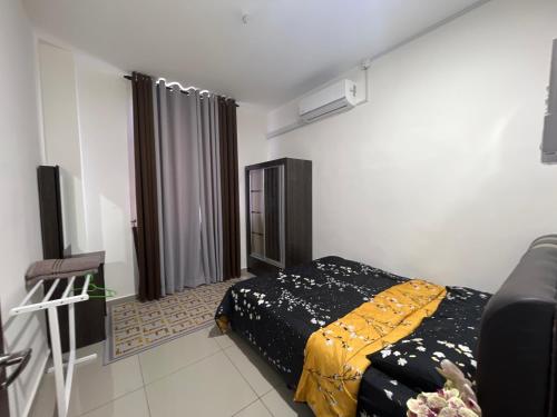 a bedroom with a bed and a couch in it at Homestay Sejahtera Pool Pokok Sena in Pokok Sena