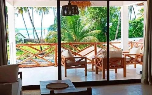 a living room with a view of the ocean at Moyo House in Jambiani