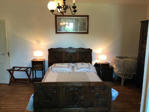 a bedroom with a large wooden bed with two lamps at Manoir de Parc ar Brun in Tréguier