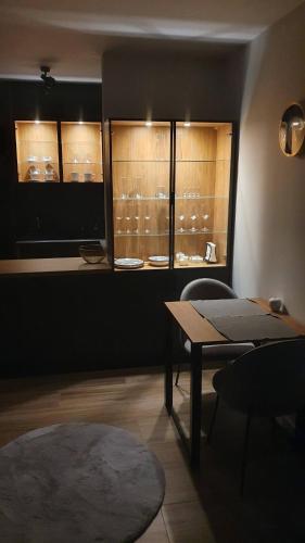 a room with a table and chairs and windows at Apartment Between in Kraków