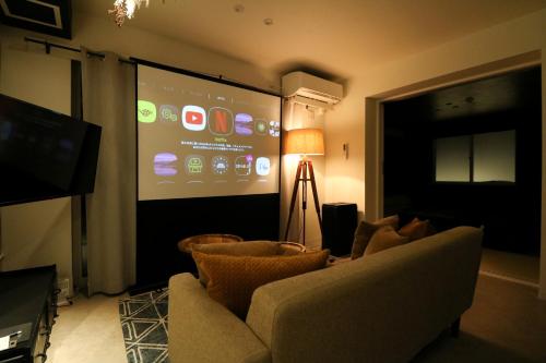 een woonkamer met een groot scherm in een kamer bij TAKETO STAY Kotoni in Sapporo