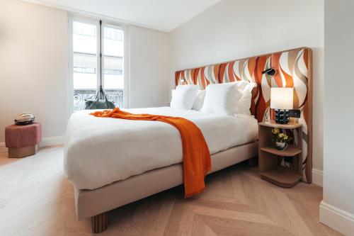 Una cama o camas en una habitación de Padam Hôtel