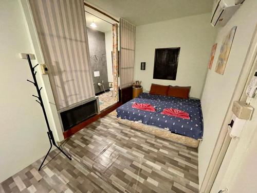 a bedroom with a bed with red pillows on it at Pano Solar Guest House (พาโน โซล่า เกสเฮ้าส์ ) in Trat