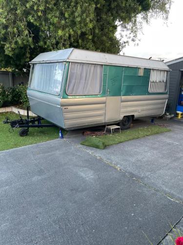 a green and silver trailer parked in a parking lot at Sandy Feet Accommodation in Christchurch