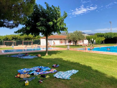 un grupo de personas yaciendo en el césped cerca de una piscina en Casa en la Valleta, en Ginestar