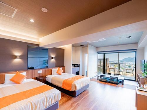 um quarto de hotel com duas camas e uma varanda em LiVEMAX RESORT Miyahama Ocean View em Hatsukaichi
