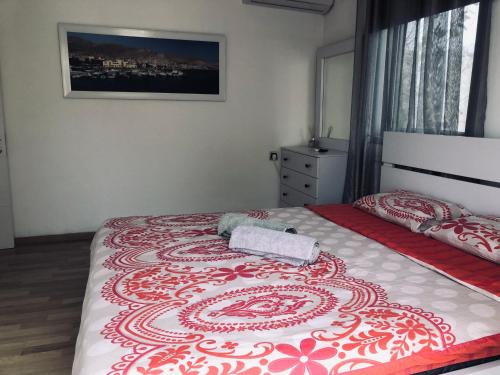 Schlafzimmer mit einem Bett mit einer roten und weißen Decke in der Unterkunft Villa Miami in Aschdod