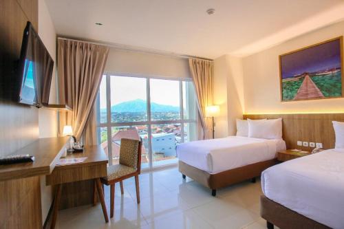 a hotel room with two beds and a desk and a desk at Horison Inn Antawirya Semarang in Jatingaleh