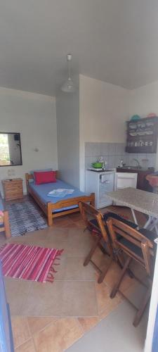 Zimmer mit einem Bett und Stühlen sowie einer Küche in der Unterkunft "STELIOS & GALINI" in Symi