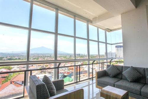 a living room with a view of the city at Horison Inn Antawirya Semarang in Jatingaleh
