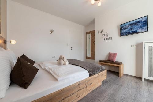 a bedroom with a bed with a teddy bear on it at Appartements Lehenhof in Sankt Johann im Pongau