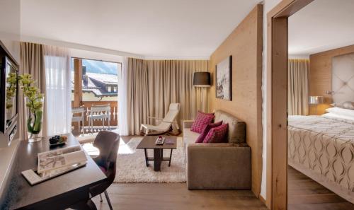 um quarto de hotel com uma cama e uma sala de estar em Giardino Bed & Breakfast em Silvaplana