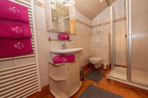 a bathroom with a sink and a shower with pink towels at Appartements Lehenhof in Sankt Johann im Pongau