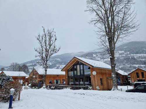 a building with snow on the ground next to a street at Aron Chalet Kreischberg 10A in Sankt Lorenzen ob Murau