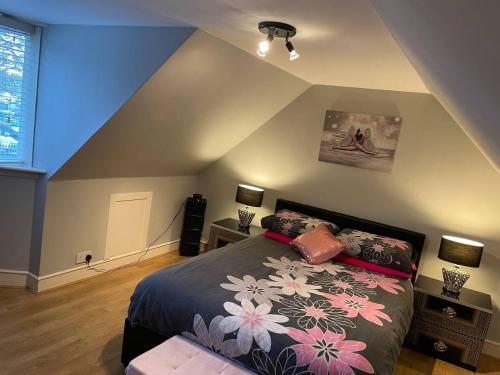 Un dormitorio con una cama con flores. en Rural Chapel Cottage near airport bar & hot tub en Aberdeen
