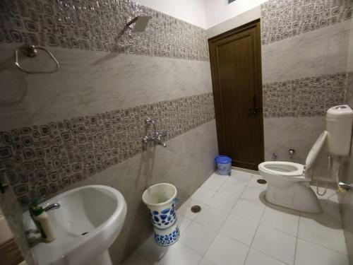 a bathroom with a toilet and a sink and a urinal at Chhabra Guest House, Kanpur in Kānpur