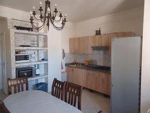 a kitchen with a table and a refrigerator at Grand appartement calme et lumineux + Parking GRATUIT in Casablanca