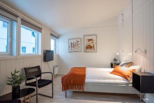 1 dormitorio con 1 cama y 1 silla en Skillevollen Motell, en Mo i Rana