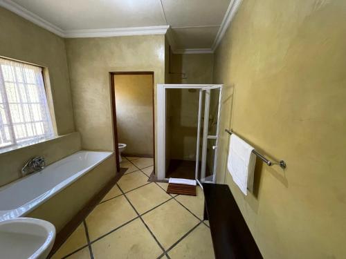 a bathroom with a bath tub and a sink at Walkersons Trout and Nature Haven in Dullstroom
