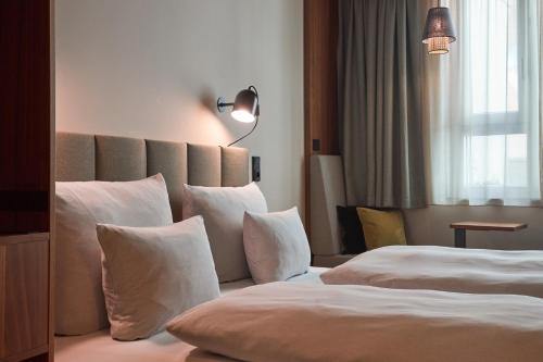 um quarto de hotel com duas camas com almofadas brancas em Cocoon Sendlinger Tor em Munique