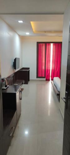 a room with a bed and a red curtain at Hotel Areeba by The Golden Taj Group & Hotels in Agra