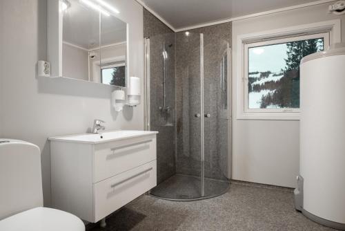 a white bathroom with a shower and a sink at Skillevollen Motell in Mo i Rana