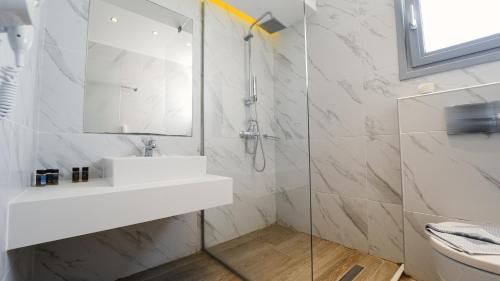 a white bathroom with a sink and a shower at Sunrise Luxury Apartments Rhodes in Rhodes Town