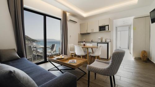 a living room with a couch and a table with chairs at Sunrise Luxury Apartments Rhodes in Rhodes Town