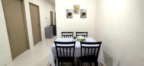 甘孟的住宿－RaiRai Homestay Gambang，餐桌、四把椅子和白色桌布