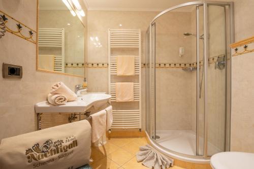 a bathroom with a shower tub and a sink at Hotel Garni Nachtigall in Schenna