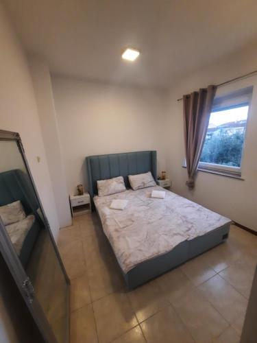 a bedroom with a large bed and a window at TIZA Apartments in Vantačići