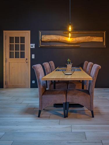a dining room table and chairs with a table and a door at A L OREE DU BOIS in Ferrières