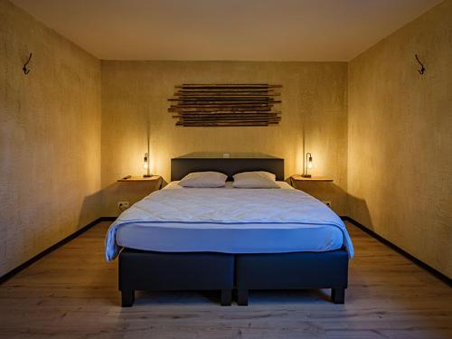 1 dormitorio con 1 cama grande y 2 luces en la pared en A L OREE DU BOIS en Ferrières
