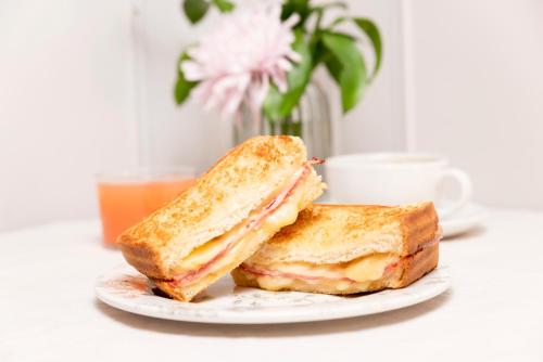 a sandwich cut in half on a plate with a cup of coffee at Hotel Sauce in Zaragoza
