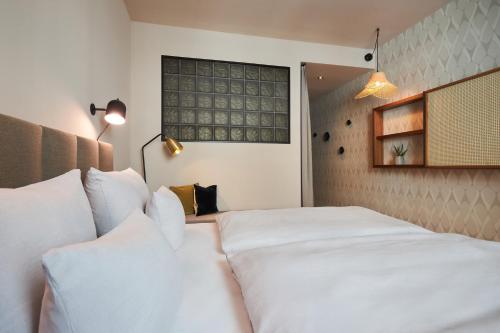 a bedroom with a large white bed with white pillows at Cocoon Sendlinger Tor in Munich