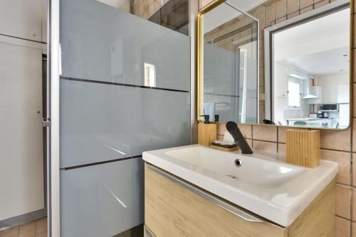 La salle de bains est pourvue d'un lavabo blanc et d'un miroir. dans l'établissement Superbe studio Vieux Nice 1 min à pied de la plage, à Nice