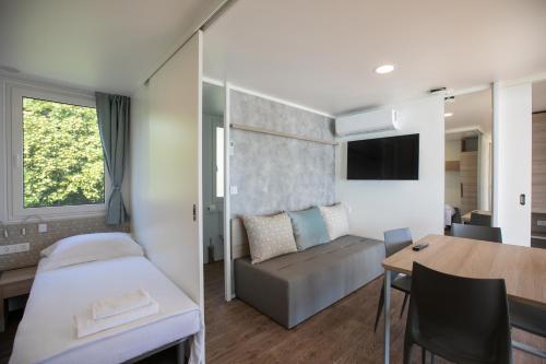 a hotel room with a bed and a table at Deluxe Beach Mobile Homes in Šibenik