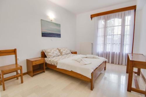 una camera con un letto e due tavoli e una finestra di The Big Cypress Apartments ad Apólpaina