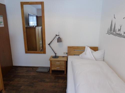 a bedroom with two beds and a mirror and a lamp at Hotel Garni Schlossblick in Hohenschwangau
